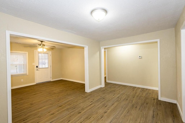 entrance foyer featuring ceiling fan, dark wood-type flooring, and a textured ceiling