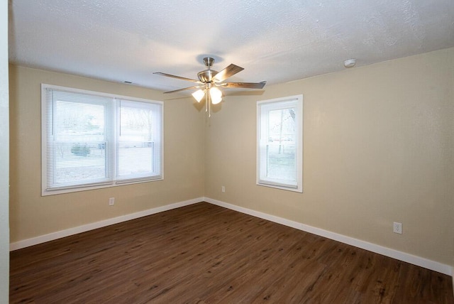 empty room featuring dark wood-type flooring, ceiling fan, and a textured ceiling