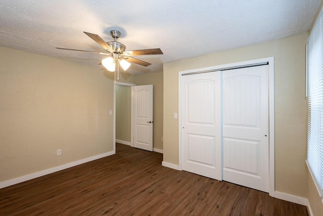 unfurnished bedroom with dark wood-type flooring, ceiling fan, a closet, and a textured ceiling