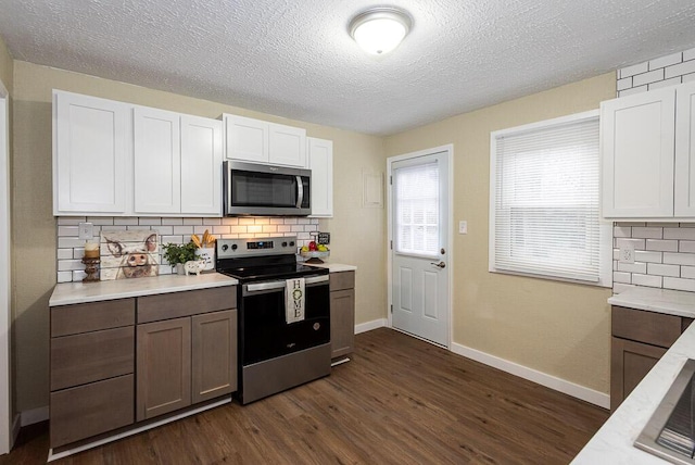 kitchen featuring appliances with stainless steel finishes, dark hardwood / wood-style floors, decorative backsplash, and white cabinets