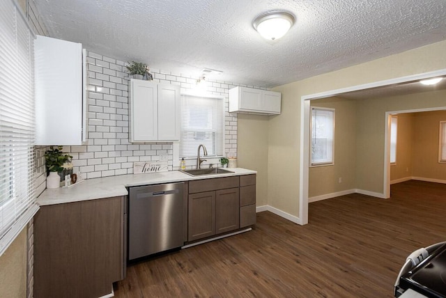 kitchen featuring dark hardwood / wood-style floors, white cabinetry, dishwasher, sink, and backsplash