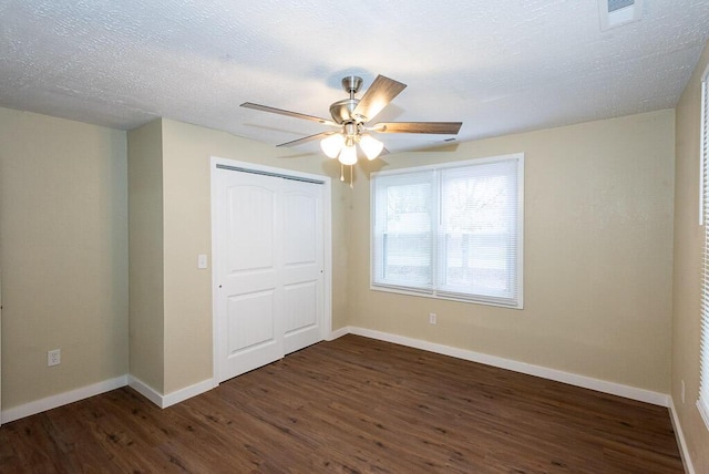 unfurnished bedroom featuring dark hardwood / wood-style flooring, ceiling fan, a closet, and a textured ceiling