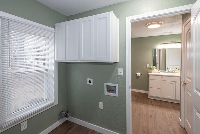 laundry room with sink, cabinets, washer hookup, light hardwood / wood-style floors, and hookup for an electric dryer