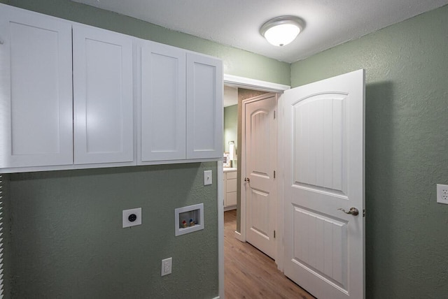 laundry room with electric dryer hookup, hookup for a washing machine, cabinets, and light wood-type flooring