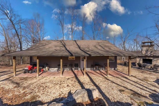 rear view of house featuring a patio and a fireplace