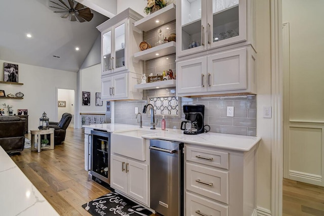 kitchen featuring white cabinets, beverage cooler, light stone countertops, light hardwood / wood-style floors, and backsplash