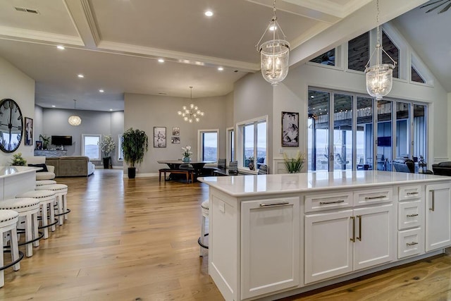 kitchen featuring white cabinetry, a center island, pendant lighting, and a chandelier