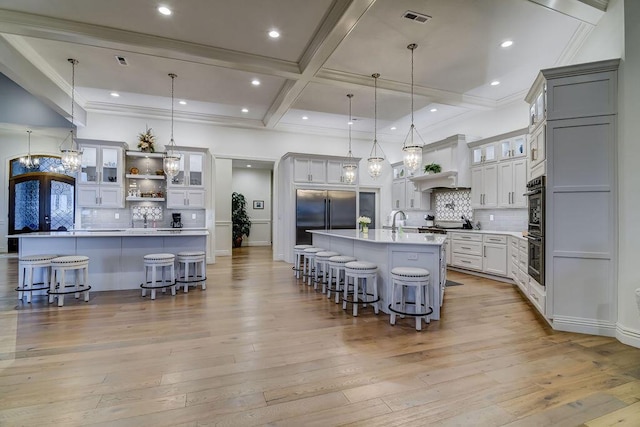 kitchen featuring stainless steel appliances, a large island, pendant lighting, and a kitchen bar