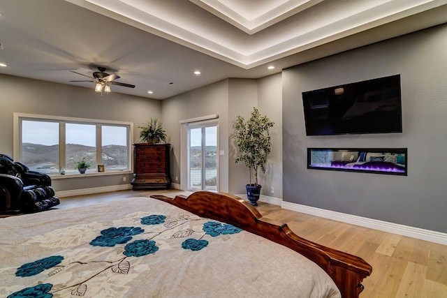 bedroom with ceiling fan, a mountain view, hardwood / wood-style floors, and access to outside