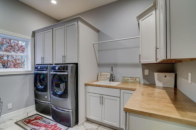 laundry room with washer and dryer, sink, and cabinets