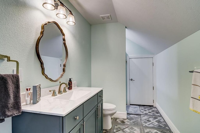 bathroom featuring vanity, vaulted ceiling, and toilet