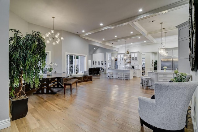 living room featuring an inviting chandelier, a high ceiling, coffered ceiling, light hardwood / wood-style floors, and beam ceiling