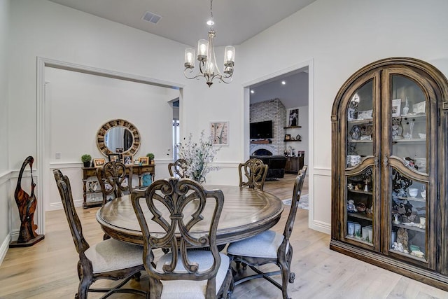 dining area with a notable chandelier and light hardwood / wood-style flooring