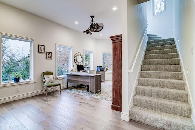 staircase featuring plenty of natural light, hardwood / wood-style floors, and a notable chandelier