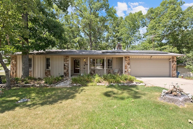 single story home with a porch, a garage, and a front lawn