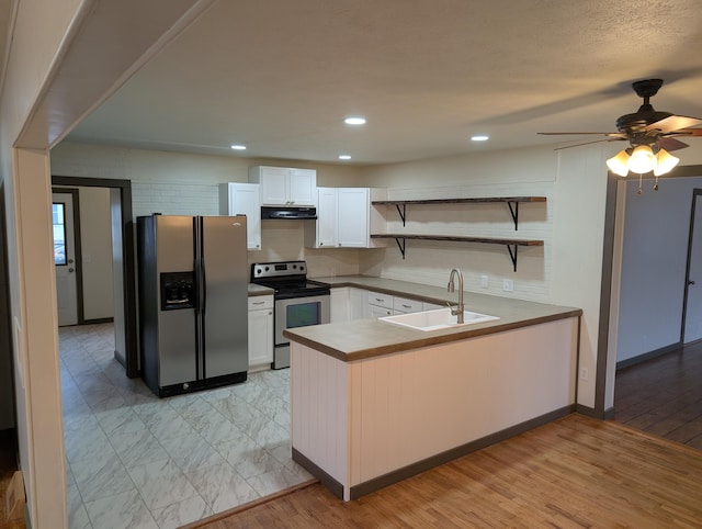 kitchen featuring sink, appliances with stainless steel finishes, kitchen peninsula, light hardwood / wood-style floors, and white cabinets