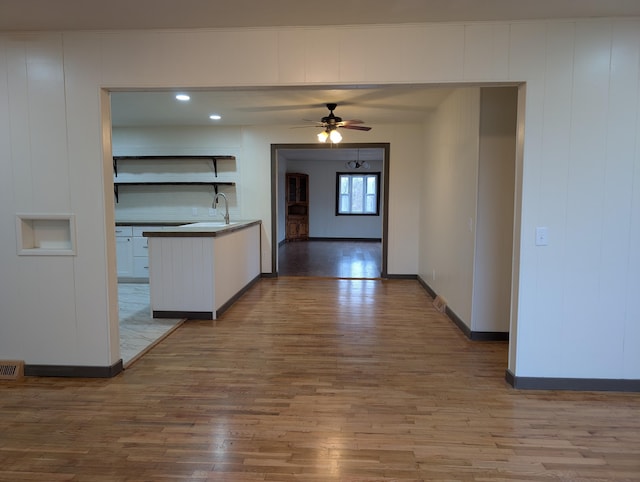 kitchen with white cabinetry, sink, hardwood / wood-style floors, and ceiling fan