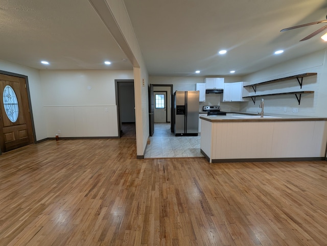 kitchen featuring sink, ceiling fan, white cabinetry, stainless steel appliances, and light wood-type flooring