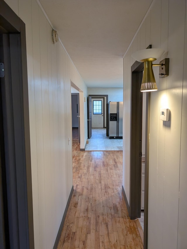 corridor featuring ornamental molding and light wood-type flooring