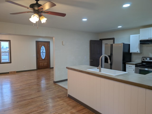 kitchen featuring sink, appliances with stainless steel finishes, tasteful backsplash, white cabinets, and light wood-type flooring