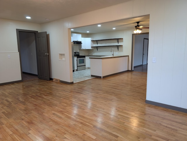 kitchen with sink, light hardwood / wood-style flooring, ceiling fan, white cabinetry, and stainless steel electric range oven