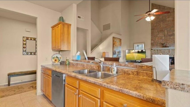 kitchen with sink, light tile patterned floors, stainless steel dishwasher, a towering ceiling, and ceiling fan