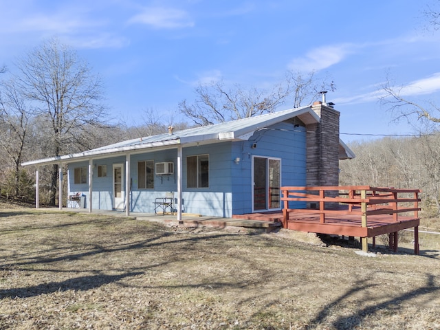 single story home with a front yard, covered porch, and a wall unit AC