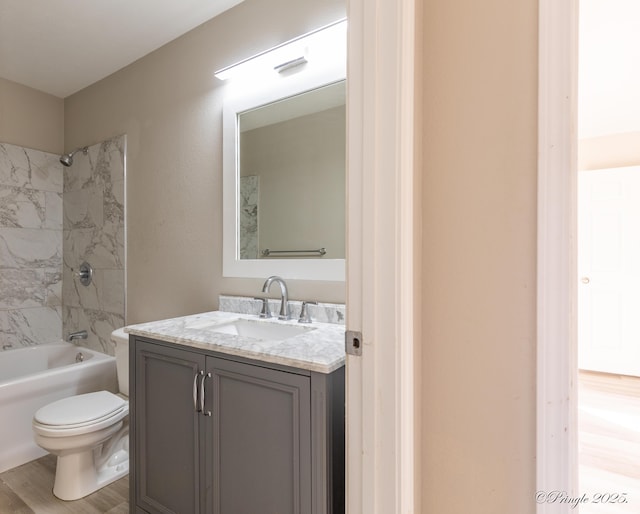 full bathroom featuring vanity, hardwood / wood-style floors, toilet, and tiled shower / bath