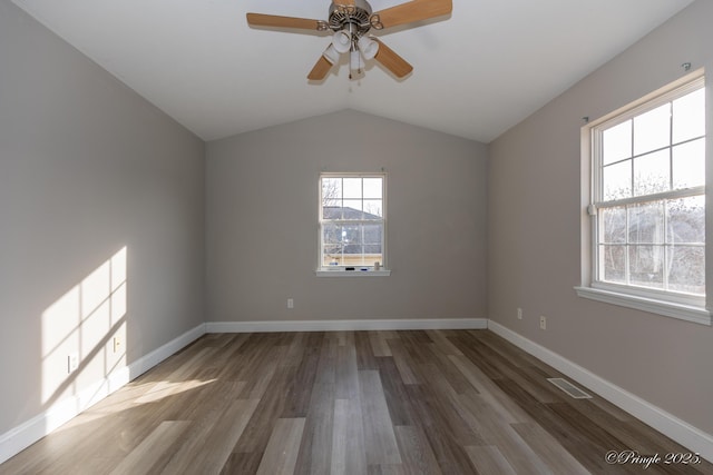 empty room with ceiling fan, wood-type flooring, and vaulted ceiling