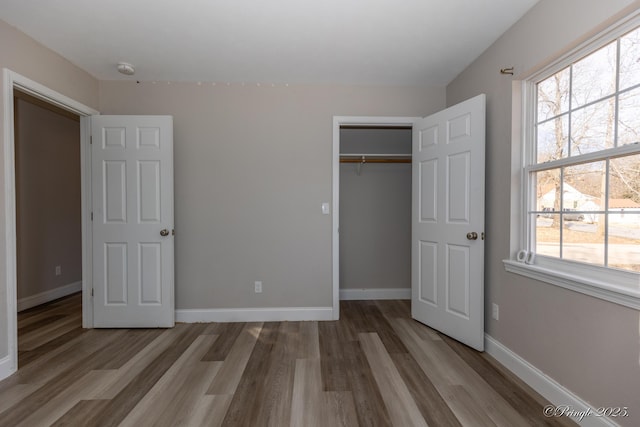 unfurnished bedroom featuring hardwood / wood-style floors and a closet