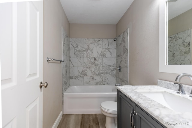 full bathroom featuring wood-type flooring, toilet, vanity, and tiled shower / bath