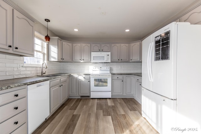 kitchen with sink, gray cabinetry, light wood-type flooring, pendant lighting, and white appliances