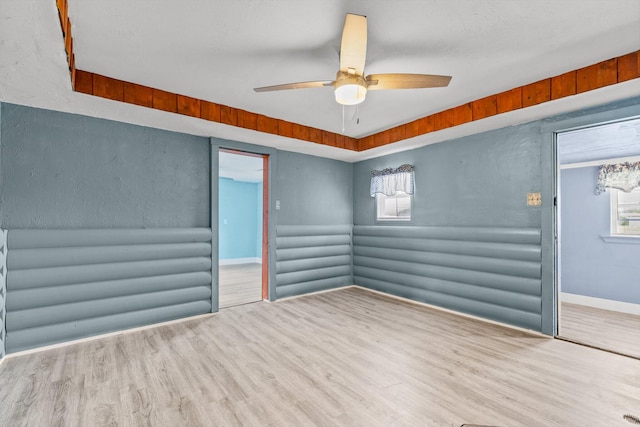 spare room with ceiling fan and light wood-type flooring