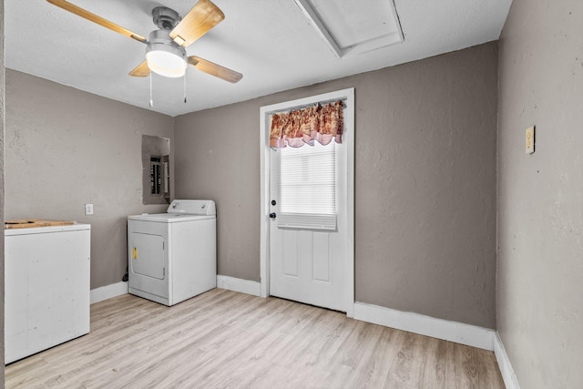 laundry room featuring independent washer and dryer, electric panel, ceiling fan, and light hardwood / wood-style flooring