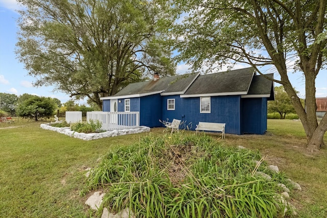 rear view of house featuring a yard