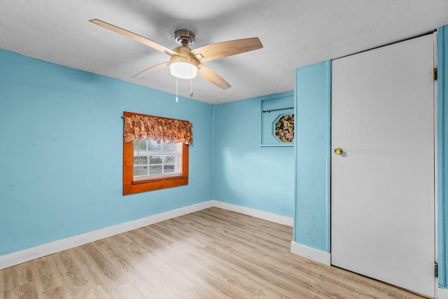 unfurnished room with ceiling fan, a textured ceiling, and light hardwood / wood-style flooring