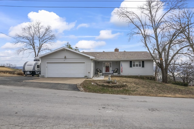 view of front of home with a garage, roof with shingles, a chimney, and aphalt driveway