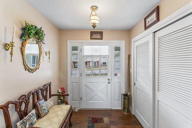 entryway with a textured ceiling and dark hardwood / wood-style flooring