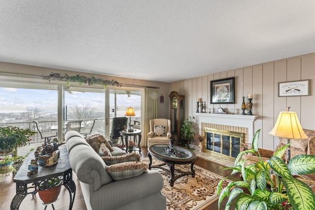 living room featuring hardwood / wood-style flooring, a fireplace, and a textured ceiling