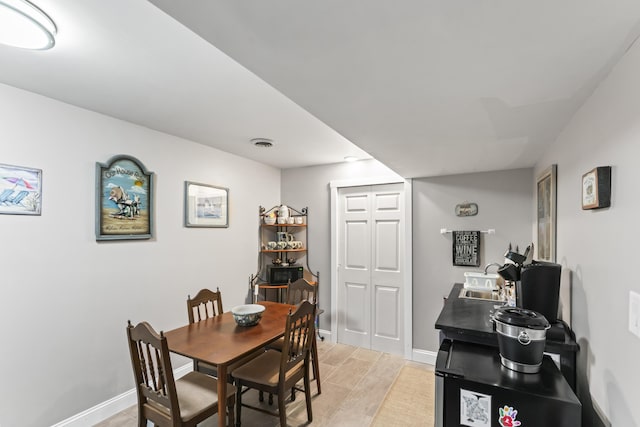 dining area with light wood-style floors, visible vents, and baseboards