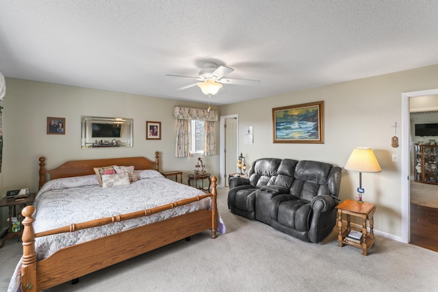 carpeted bedroom with ceiling fan and a textured ceiling