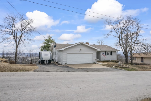 view of front of house with a garage, driveway, and a chimney