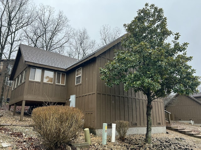 view of property exterior with a shingled roof