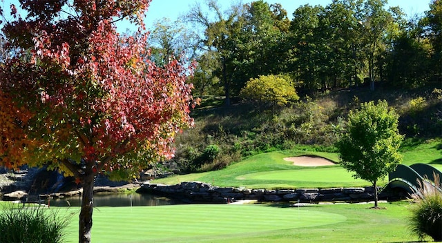 surrounding community with view of golf course and a yard