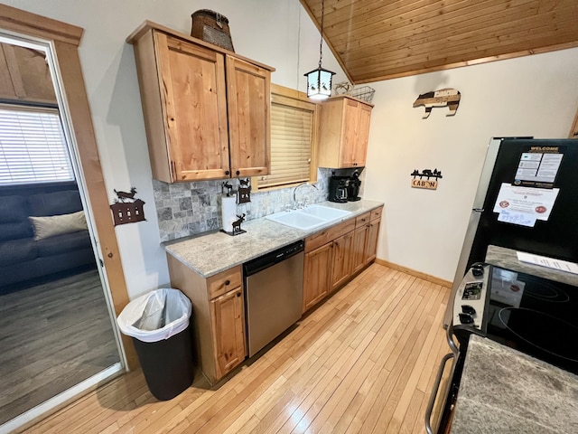 kitchen featuring lofted ceiling, light wood-style flooring, a sink, stainless steel appliances, and backsplash