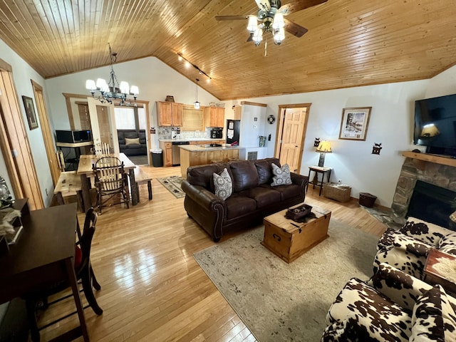 living area featuring lofted ceiling, light wood-style floors, a stone fireplace, wooden ceiling, and ceiling fan with notable chandelier