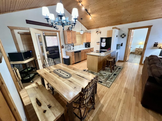 dining room with light wood finished floors, wood ceiling, track lighting, and a notable chandelier