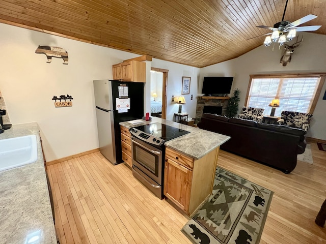 kitchen with stainless steel appliances, lofted ceiling, a sink, and light wood finished floors