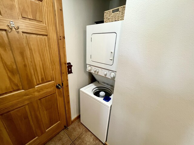 washroom with stacked washer and dryer, tile patterned flooring, and laundry area