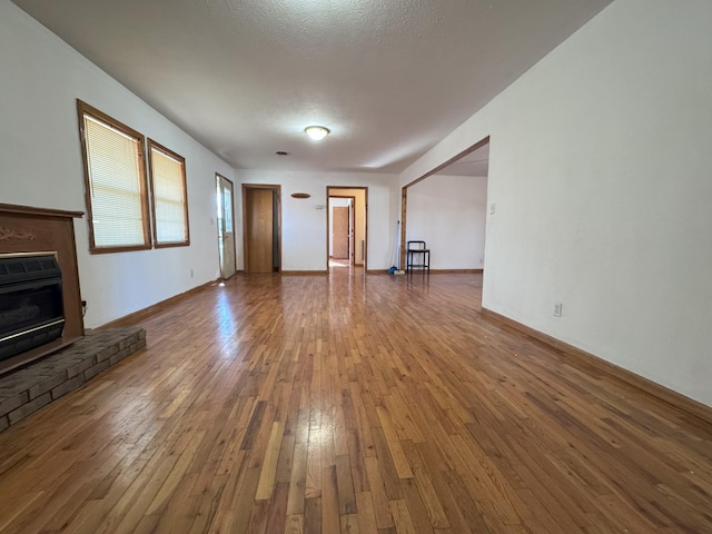 unfurnished living room with hardwood / wood-style flooring and a textured ceiling